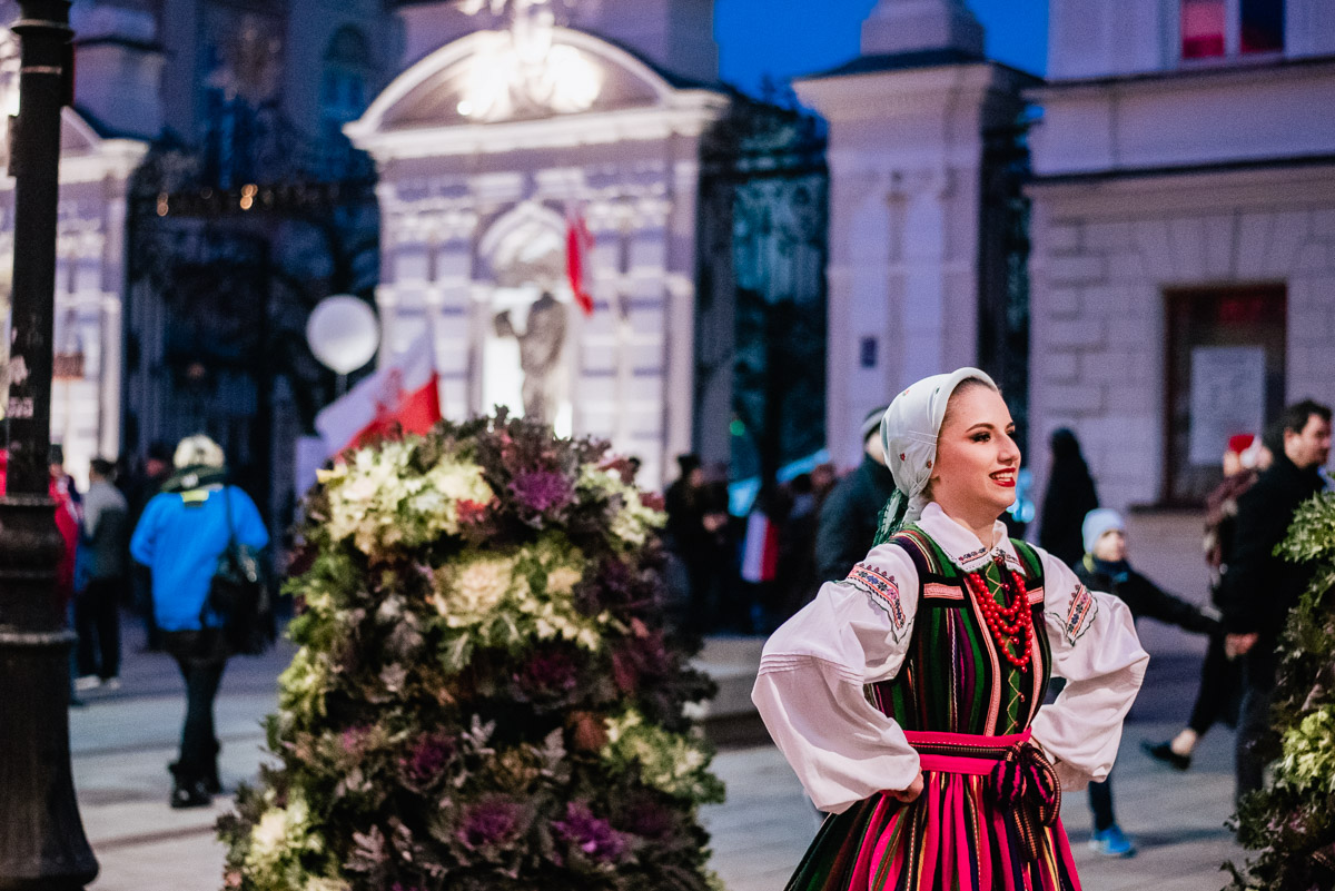 : A woman in a folk costume during an artistic performance in Krakowskie Przedmieście in Warsaw