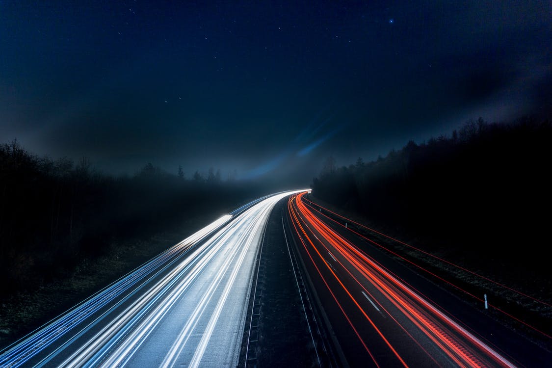 widok drogi nocą ze smugami świateł samochodów