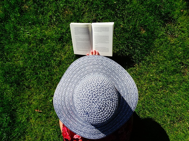 kobieta czytająca książkę w kapeluszu z wielkim rondem