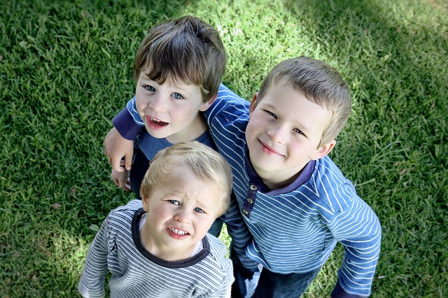 trójka chłopców na trawie
