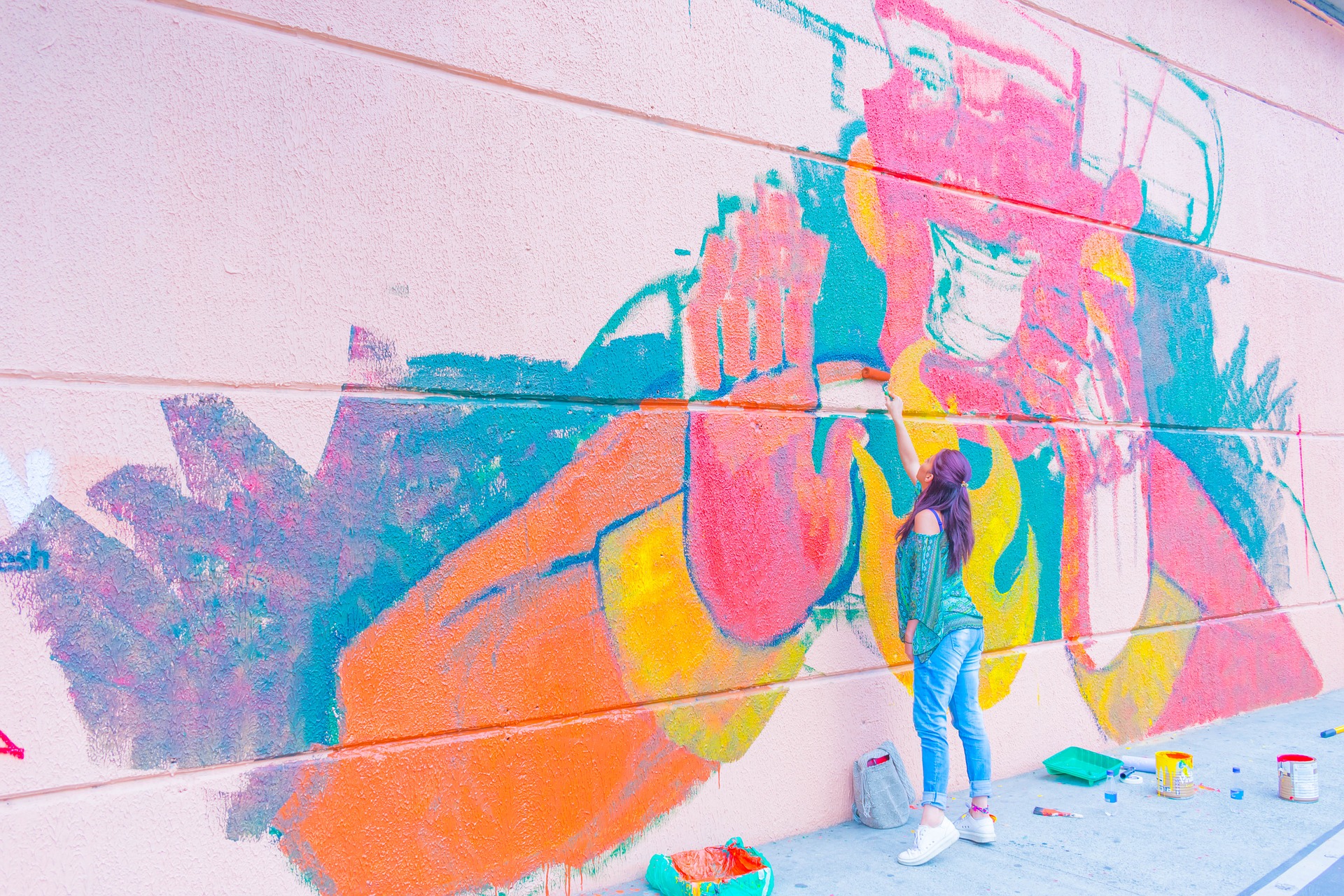 dziewczyna maluje mural na ścianie