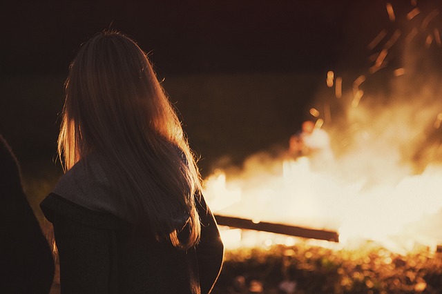dziewczyna stojąca przy ognisku