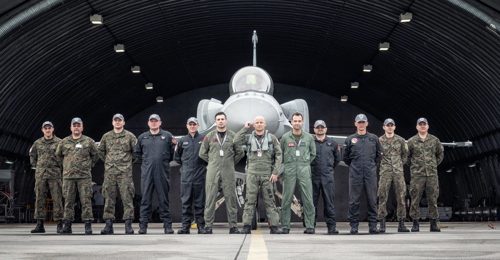 mężczyźni w mundurach stojący przed samolotem
