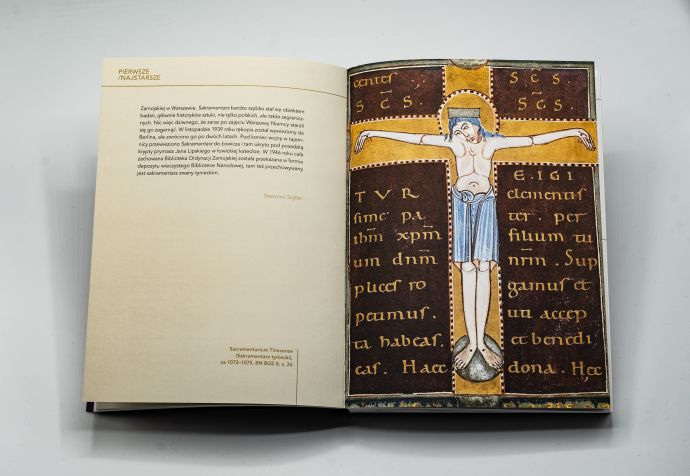 zdjęcie otwartej książki przedstawiającej miniaturę z wizerunkiem ukrzyżowanego Jezusa skomponowanego na literze T