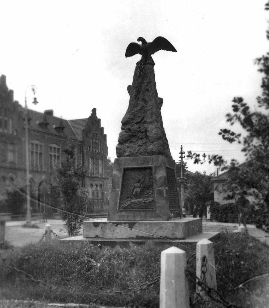 pomnik z płaskorzeźbą żołnierza na cokole zwieńczony sylwetką orła