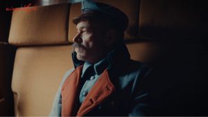 Piłsudski w płaszczu w przedziale kolejowym patrzy się przez okno