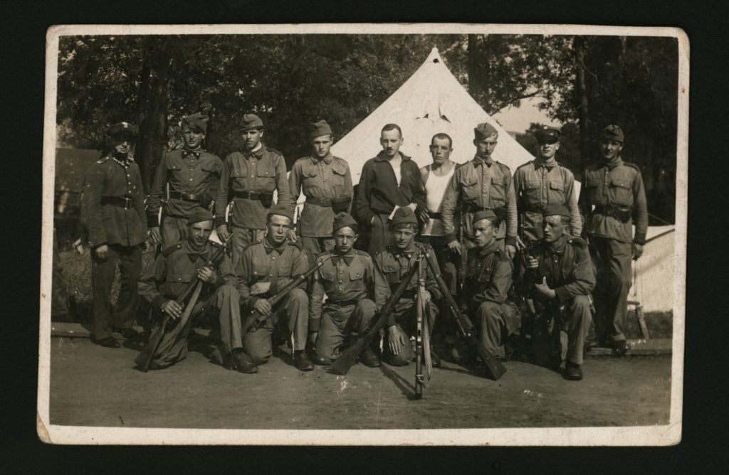 grupa żołnierzy pozująca do zdjęcia przed namiotem