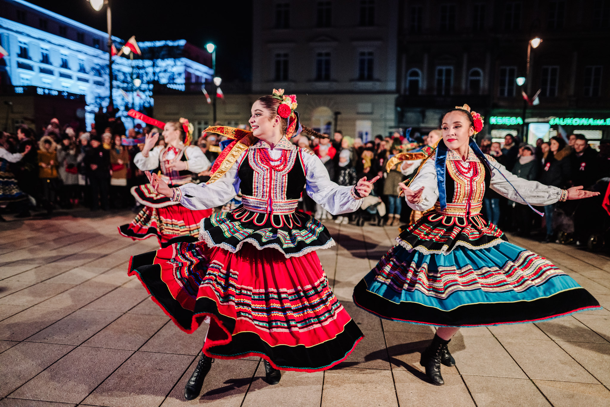 kobiety w strojach ludowych tańczące na ulicy