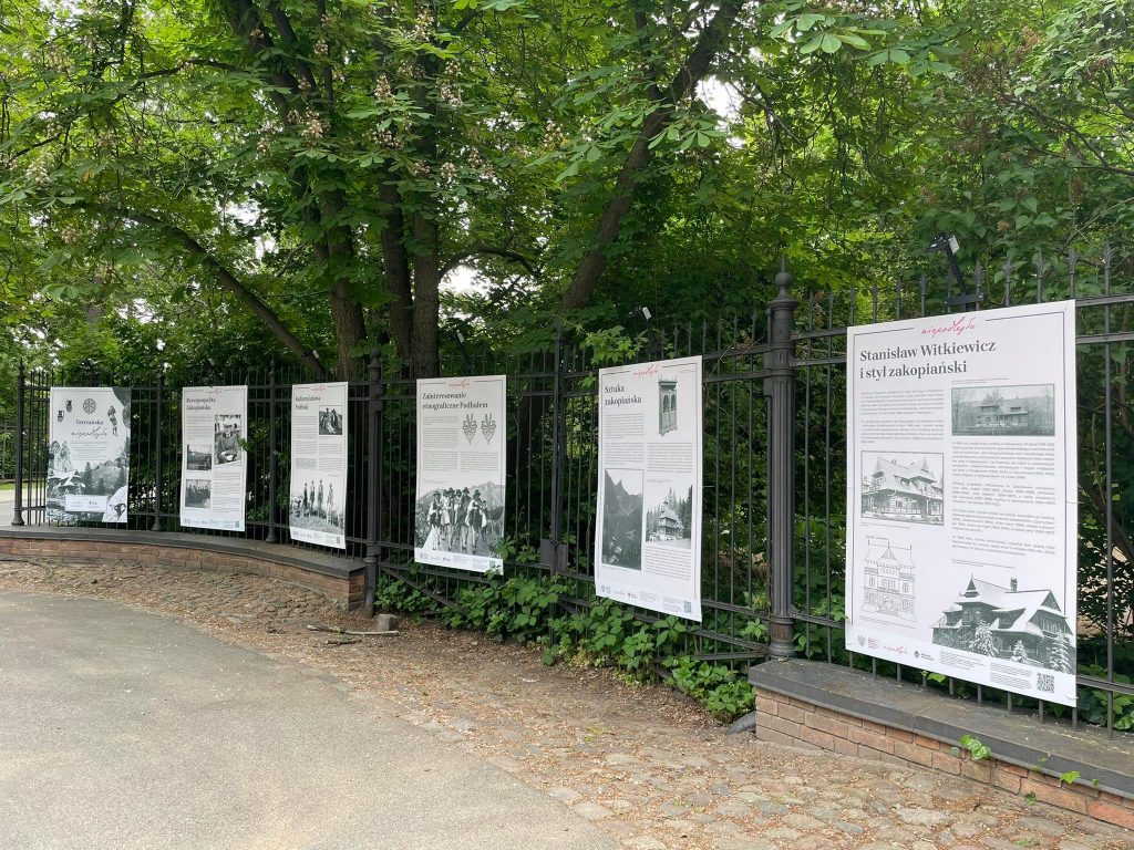 plansze wystawy rozwieszone w równych odstępach na płocie Łazienek