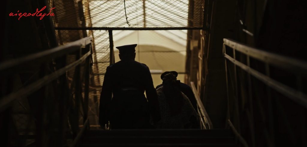 kobieta prowadzna do celi przez dwóch żandarmów