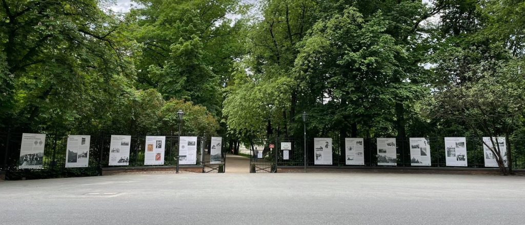 plansze wystawy rozwieszone w równych odstępach na płocie Łazienek