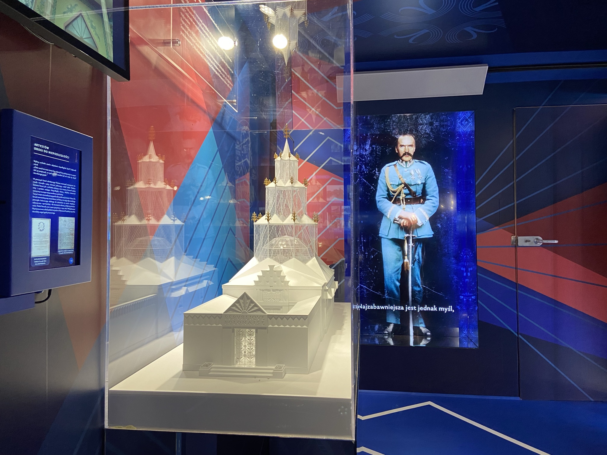 zdjęcie ukazujące makietę pawilonu i hologram marszałka multimedialny i fragment dekoracji graficznej wnętrza tira