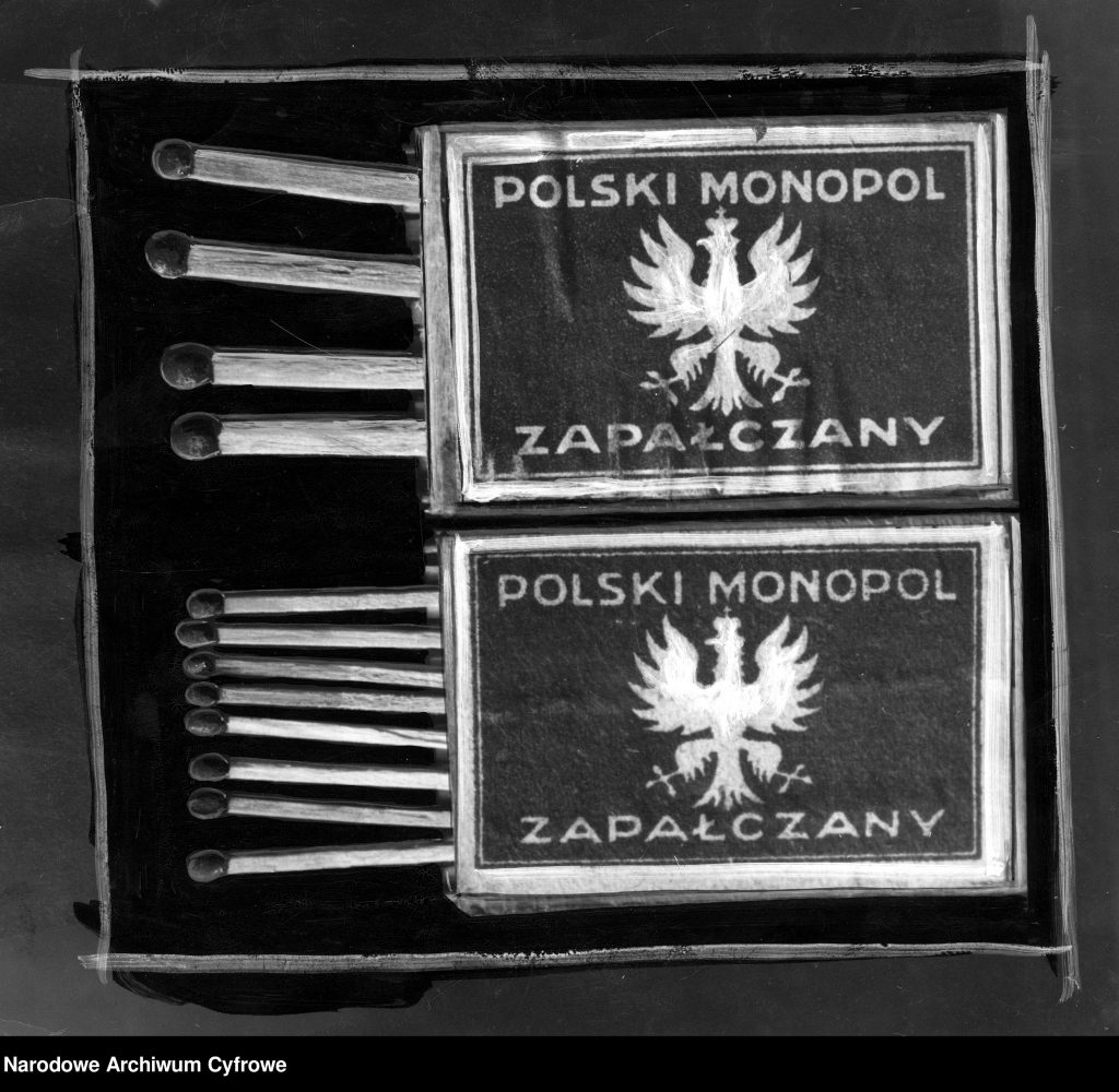otwarte pudełka zapałek, na nich znaczek z białym orłem na ciemnym tle i napisem polski monopol zapałczany