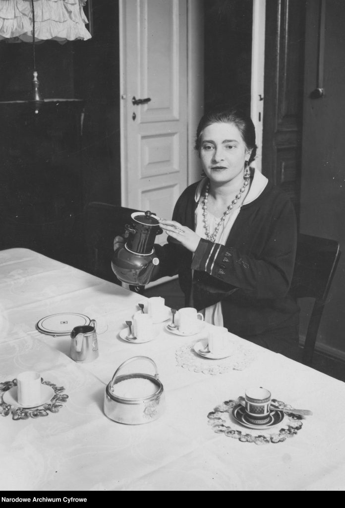 kobieta trzyma dzbanek w dłoni i nalewa kawę do filiżanek