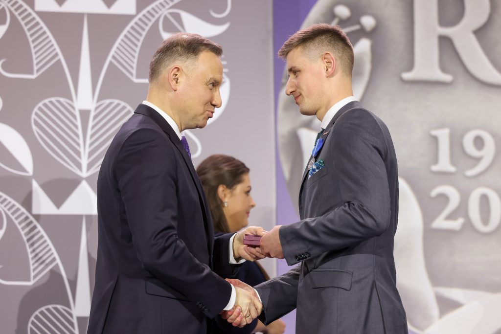 dyrektr Kirejczyk odbiera medal z rąk prezydenta Dudy