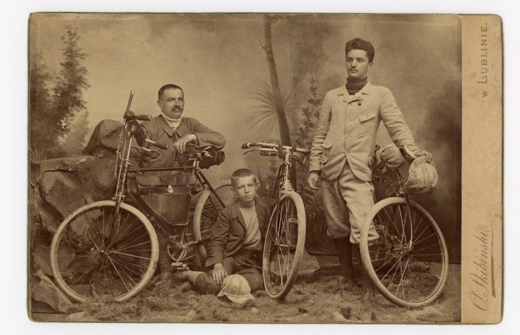 trzech mężczyzn z rowerami pozuje do zdjęcia