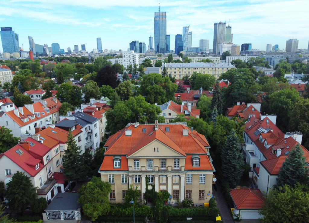 widok z lotu ptaka na osiedle, w tle zabudowa nowoczesnych wieżowców w centrum Warszawy