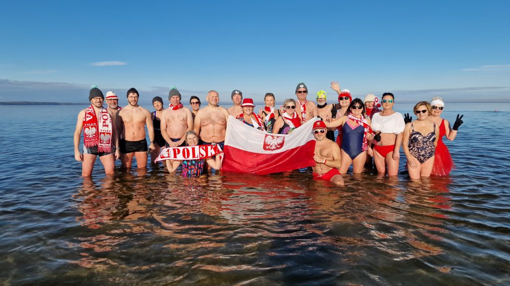 grupa morsów podczas kąpieli z flagą polski