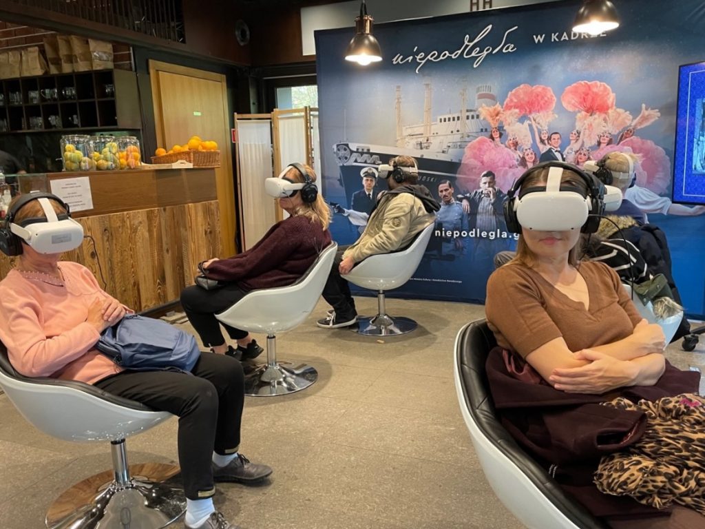 ludzie w goglach VR oglądający film w przestrzeni pawilonu