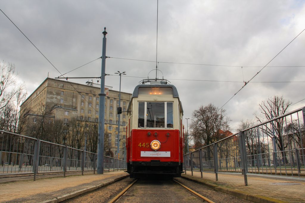 wagon tramwajowy retro na szynach, w tle architektura modernistyczna