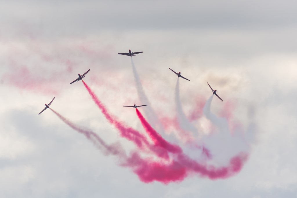 samoloty w trakcie pokazu, wypuszczają biały i czerwony dym