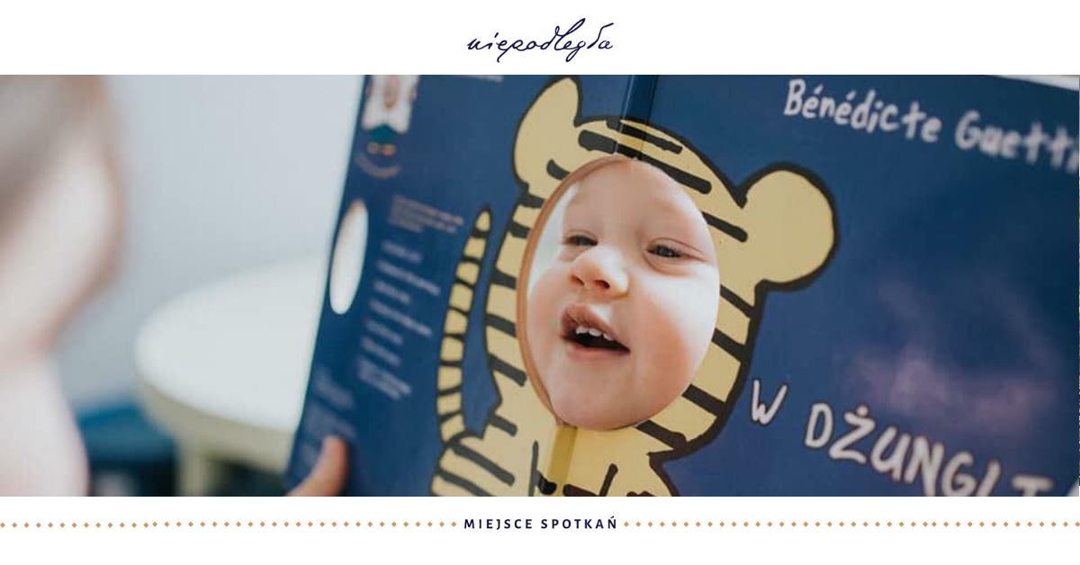 baner z dzieckiem wkładającym buzię w dziurę w książce z obrysem tygryska
