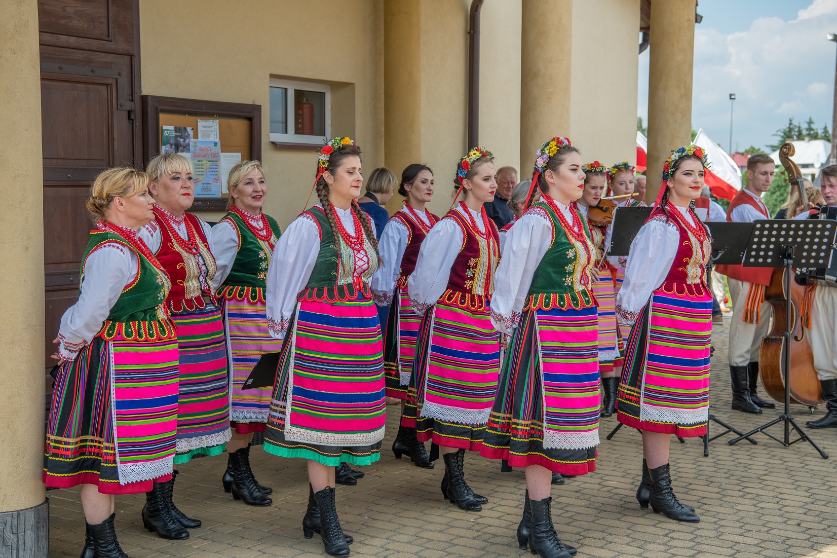 Zespół Narwianie podczas koncertu w Bielsku Podlaskim. Grupa tańczących osób w barwnych, ludowych strojach
