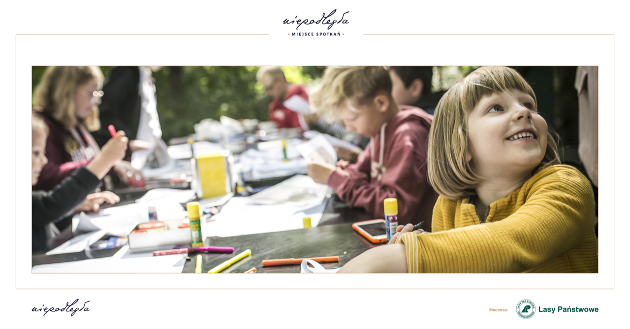 Zdjęcie przedstawia dzieci wykonujące prace plastyczne przy stole w ogródku pawilonu Niepodległa. Miejsce spotkań