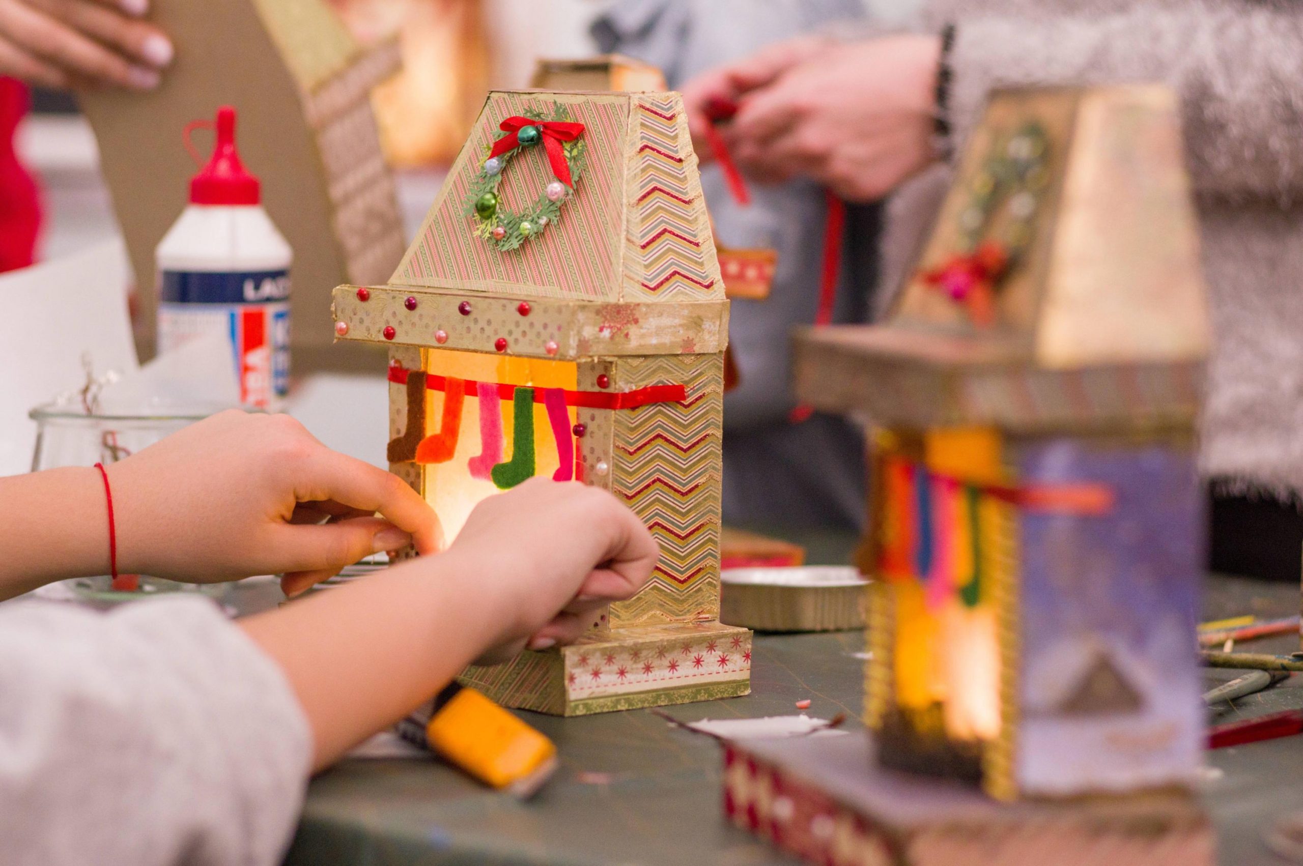 Zdjęcie przedstawia warsztaty, podczas których wykonywane są dekoracyjne kominki świąteczne.